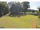 View of the expansive backyard featuring grass and mature trees at 195 Twin Oaks Dr, Hampton, GA 30228
