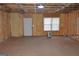 Unfinished basement featuring new insulation, a door to the backyard, and a window at 195 Twin Oaks Dr, Hampton, GA 30228