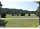 Backyard features a grass lawn, trees, and a paved driveway at 195 Twin Oaks Dr, Hampton, GA 30228