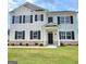 Beautiful two-story home featuring a white exterior, black shutters, landscaped lawn and covered front porch at 363 Friendship Oak Way, Hampton, GA 30228
