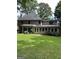 Back exterior view of a two-story home with a sunroom and a well-maintained lawn at 4887 Winterview Ln, Douglasville, GA 30135