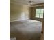 Spacious main bedroom featuring neutral walls, carpet, tray ceiling with fan and a window at 4887 Winterview Ln, Douglasville, GA 30135