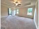Spacious main bedroom featuring neutral walls, carpeted floor, ceiling fan and plenty of natural light at 542 Hinton Farm Way, Dacula, GA 30019