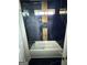 Chic bathroom featuring a bathtub with stylish black and gold tile surround and glass enclosure at 6409 Caledon Ct, Locust Grove, GA 30248