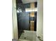 Bathtub showcasing chic marble and gold tiled walls with glass shower door at 6409 Caledon Ct, Locust Grove, GA 30248