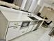 Kitchen island features a stainless steel sink, microwave, and modern white cabinets with gold hardware at 6409 Caledon Ct, Locust Grove, GA 30248