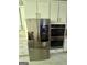 Kitchen with stainless steel appliances, including a large refrigerator and double wall ovens, with white cabinetry at 6409 Caledon Ct, Locust Grove, GA 30248