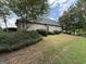 The side yard has green grass and neatly trimmed bushes at 6409 Caledon Ct, Locust Grove, GA 30248