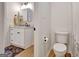 Compact half bathroom with a modern vanity, toilet, and vinyl floors at 551 Lees Mill Rd, Fayetteville, GA 30214