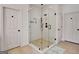 Modern bathroom featuring an enclosed glass shower with white tile surround and neutral tile floor at 551 Lees Mill Rd, Fayetteville, GA 30214