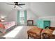 Bright bedroom with a sloped ceiling, light carpet, sitting area, and a turquoise dresser at 551 Lees Mill Rd, Fayetteville, GA 30214