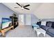 Bright bonus room featuring a cozy sofa, modern ceiling fan, and open doorway at 551 Lees Mill Rd, Fayetteville, GA 30214