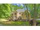 Elegant stucco home with manicured landscaping and a lush, green lawn surrounded by mature trees at 551 Lees Mill Rd, Fayetteville, GA 30214