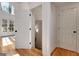 Sunlit hallway with hardwood floors showcasing access to multiple rooms and stairway at 551 Lees Mill Rd, Fayetteville, GA 30214