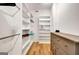 Spacious walk-in closet with custom shelving and a dresser with neutral stain on hardwood floors at 551 Lees Mill Rd, Fayetteville, GA 30214