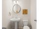 Powder room featuring a pedestal sink, modern mirror, and stylish lighting at 332 Sinclair Ct # 77, Mcdonough, GA 30253