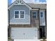 Charming home featuring a garage, brick accents, and blue shingle siding at 332 Sinclair Ct # 77, Mcdonough, GA 30253
