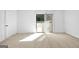 Bright bedroom features neutral carpet, a sliding glass door, and white walls at 843 Seasons Pkwy, Norcross, GA 30093