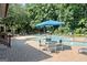 Community swimming pool area with seating and a large blue umbrella at 843 Seasons Pkwy, Norcross, GA 30093