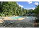 Community swimming pool with brick surround, lounge chairs, and green trees at 843 Seasons Pkwy, Norcross, GA 30093