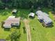 A beautiful aerial view of a farmhouse with a metal roof surrounded by lush greenery at 323 Hollonville Rd, Brooks, GA 30205