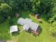 A charming property features multiple buildings and carports surrounded by verdant forestry at 323 Hollonville Rd, Brooks, GA 30205