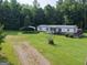 A white single-story home with a metal roof, a spacious yard, and a convenient carport at 323 Hollonville Rd, Brooks, GA 30205