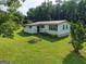 A light green, single-story home with a metal roof and well-maintained lawn at 323 Hollonville Rd, Brooks, GA 30205