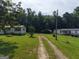 Two single-story homes with carports are nestled in a vast yard surrounded by lush trees at 323 Hollonville Rd, Brooks, GA 30205