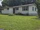A charming single-story home boasts a metal roof and a large, green yard at 323 Hollonville Rd, Brooks, GA 30205