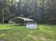 A shady carport, storage shed, and water well feature in the expansive yard of this property at 323 Hollonville Rd, Brooks, GA 30205