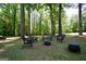 Scenic backyard firepit with a seating area among mature trees at 85 Eastwood Frst, Covington, GA 30014