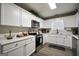 Bright kitchen with white cabinets, stainless steel appliances, and laminate flooring at 85 Eastwood Frst, Covington, GA 30014