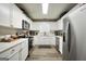 Bright kitchen with white cabinets, stainless steel appliances, and laminate flooring at 85 Eastwood Frst, Covington, GA 30014