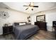 Comfortable main bedroom features neutral walls, tray ceiling, ceiling fan, and laminate flooring at 85 Eastwood Frst, Covington, GA 30014