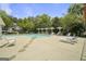 Community swimming pool with lounge chairs, umbrellas, and trees in the background at 2203 Hyssop Way, Buford, GA 30519