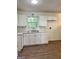 Bright kitchen with white cabinets, wood-look flooring, and natural light from the window at 4688 Brice Dr, Union City, GA 30291