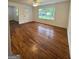 Bright living room with hardwood floors, a ceiling fan, and large windows overlooking the front yard at 4688 Brice Dr, Union City, GA 30291