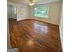 Bright living room with hardwood floors, a ceiling fan, and large windows overlooking the front yard at 4688 Brice Dr, Union City, GA 30291