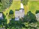 Aerial view showcasing the home's backyard with a patio, surrounded by trees and a well-manicured lawn at 2866 Rosecommons Dr, Hampton, GA 30228