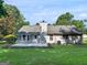 Rear exterior view of the home featuring a concrete patio, lush lawn, and fenced yard at 2866 Rosecommons Dr, Hampton, GA 30228