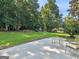 Expansive backyard featuring a stone patio with outdoor seating and a lush green lawn extending to a wooded area at 2866 Rosecommons Dr, Hampton, GA 30228