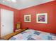 Red bedroom featuring decorative wall art, a single chair, and a comfortable bed, creating a cozy ambiance at 2866 Rosecommons Dr, Hampton, GA 30228