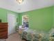 Bright green-walled bedroom with a single bed, dresser, and natural light from a window, creating a calming space at 2866 Rosecommons Dr, Hampton, GA 30228