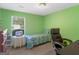 Bright, green-walled bedroom with a single bed, desk and chair, perfect for work or relaxation at 2866 Rosecommons Dr, Hampton, GA 30228