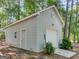 Detached garage with a white garage door and side entry, nestled in a wooded lot at 2866 Rosecommons Dr, Hampton, GA 30228