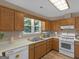 Kitchen featuring light countertops, white appliances, and wood-tone cabinets at 2866 Rosecommons Dr, Hampton, GA 30228