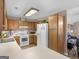 Kitchen featuring light countertops, white appliances, and wood-tone cabinets at 2866 Rosecommons Dr, Hampton, GA 30228