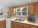 Kitchen featuring light countertops, white appliances, and wood-tone cabinets at 2866 Rosecommons Dr, Hampton, GA 30228