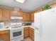 Kitchen featuring light countertops, white appliances, and wood-tone cabinets at 2866 Rosecommons Dr, Hampton, GA 30228